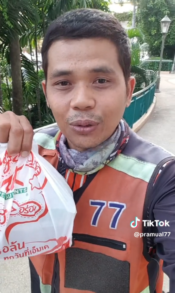 The motorcycle taxi driver showing the free meal he was gifted.