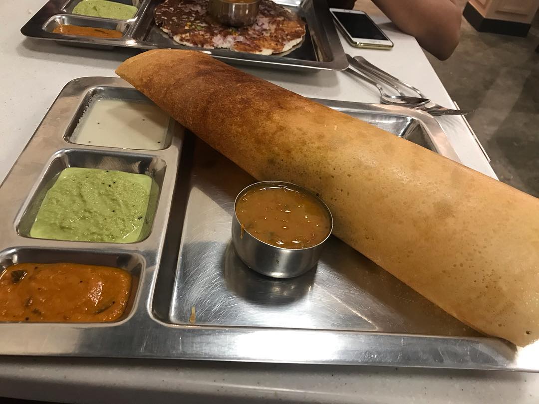 A plate of dosa with dipping sauces served at Saravana Bhavan.