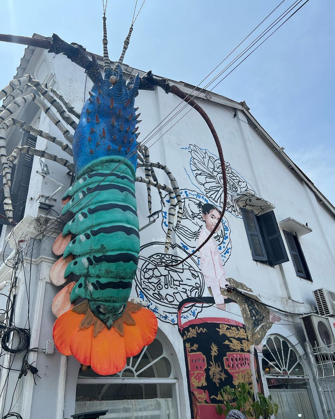 A huge colourful lobster decoration hanging off the side of Tu Kab Khao in Phuket Old Town.