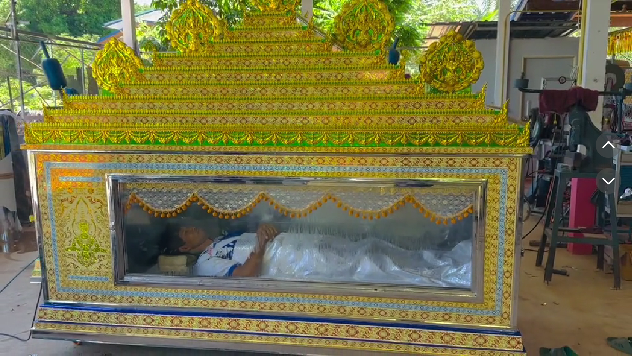 man lying in coffin