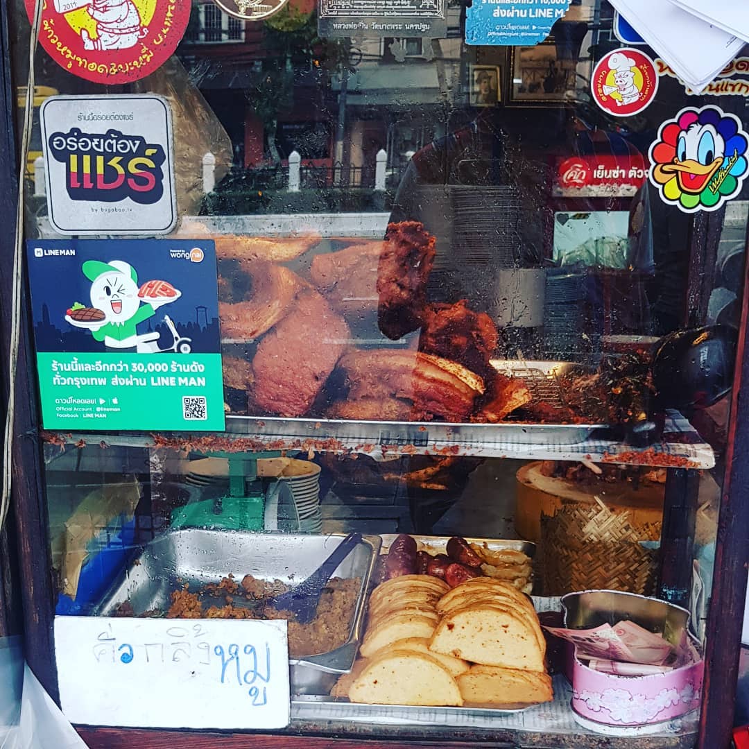 The street food stall Baan Khaek Fried Pork showcasing their assortment of fried pork and sausages. 