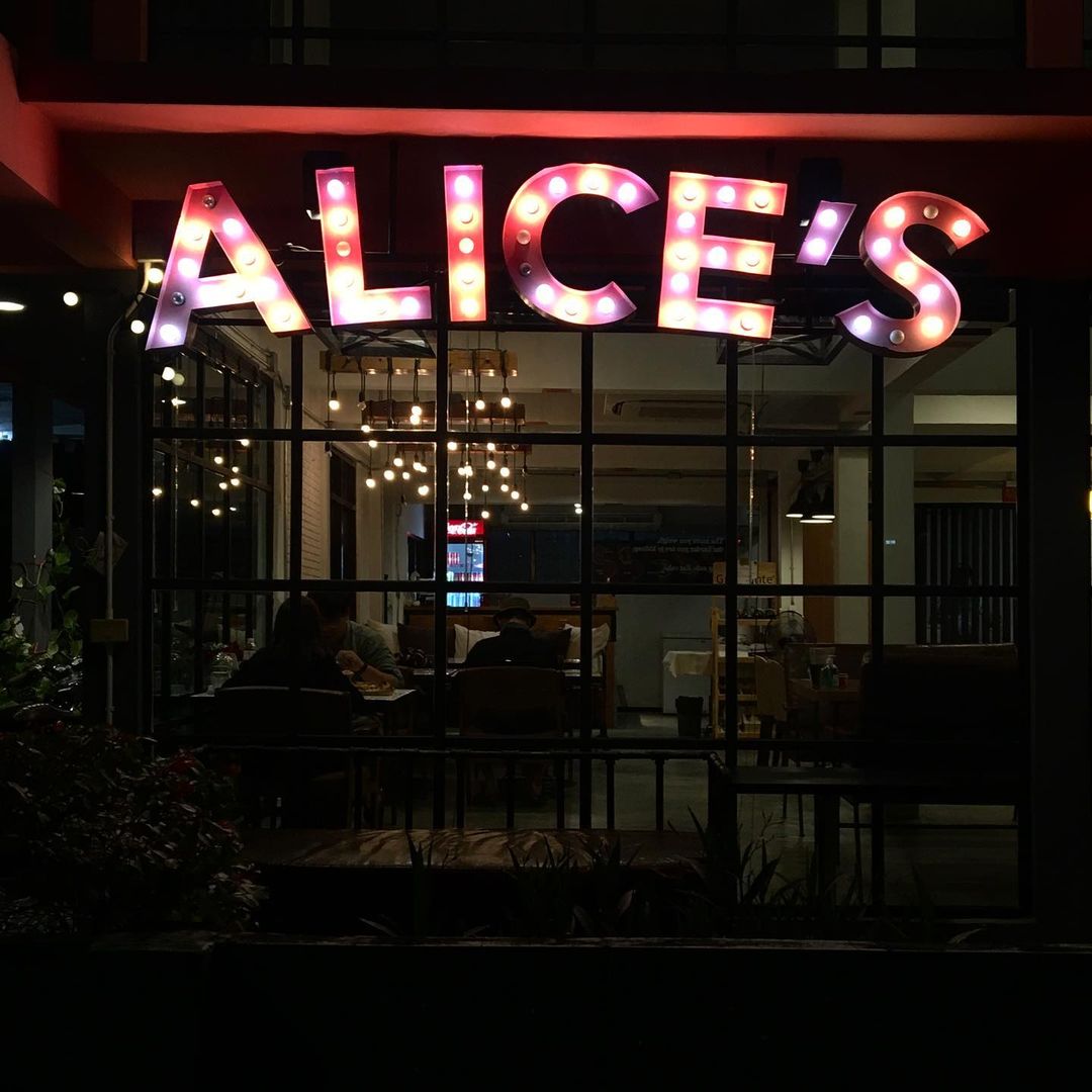The low-key Alice's Pizza restaurant with neigbourhood vibes lit up by their neon sign. 