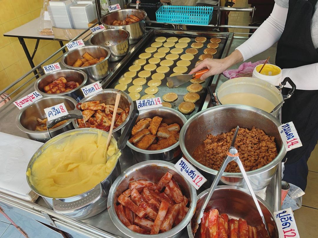 The selection of savoury fillings at aKhanom Tokyo St. Louis 3 including sausages, ham, and fried chicken. 