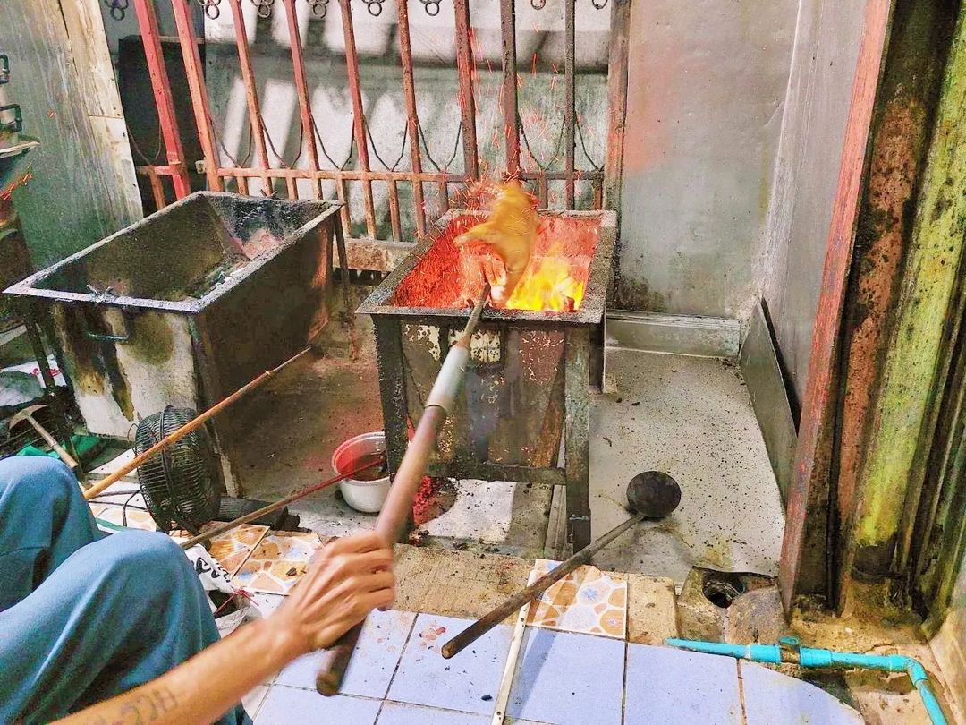 A suckling pig being roasted over a charcoal fire. 