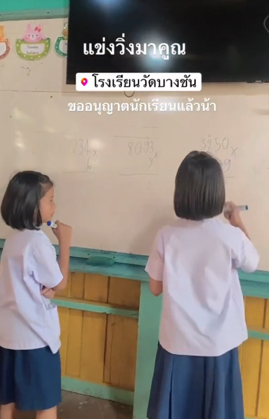 Two primary school students in Chantaburi solving math problems on the white board.