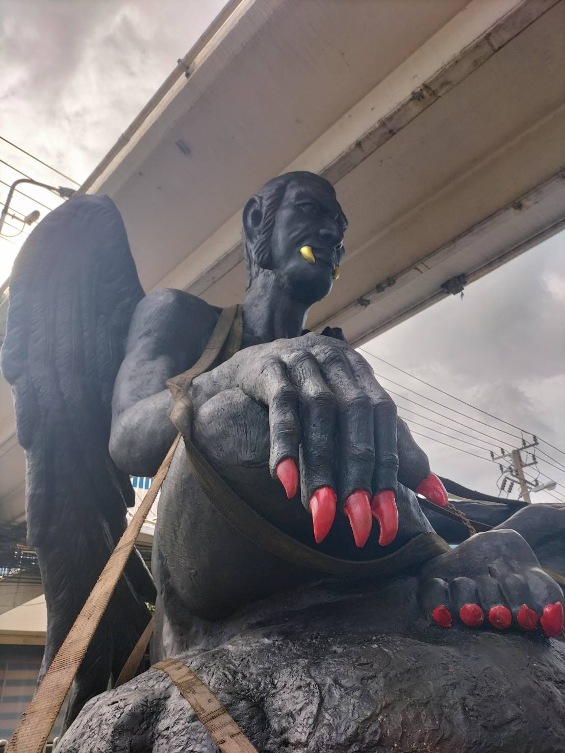 The Thai Mystical Statue with its bright yellow fangs, red nails, and wings. 