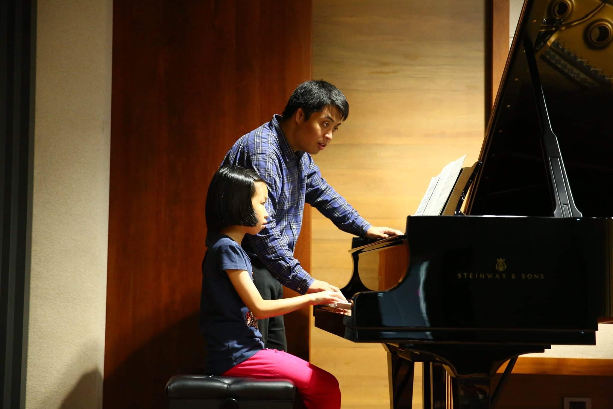 A teacher instructing a student to play the piano at Baan Plook Rak. 