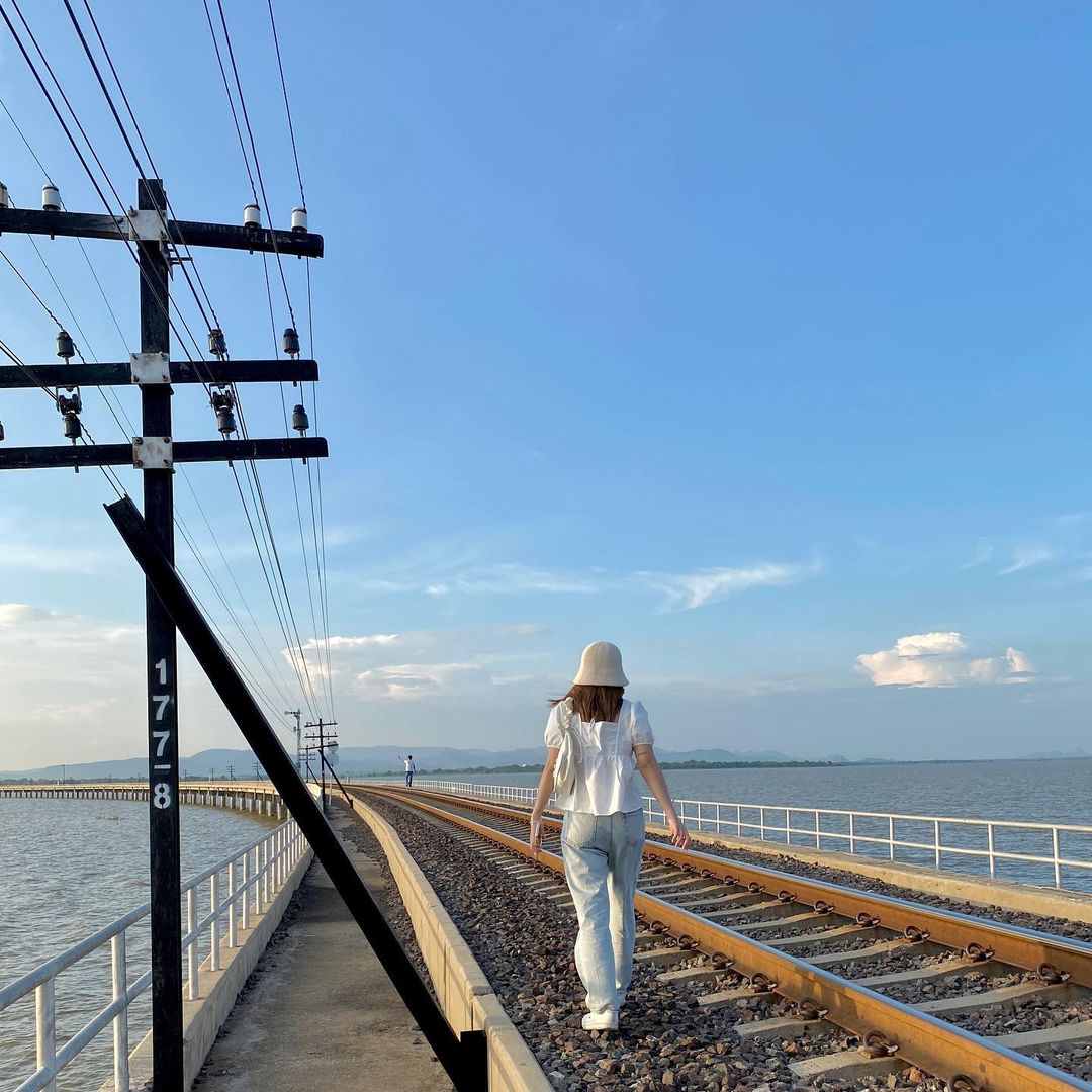 A woman posing for a photo along the train tracks of the floating train