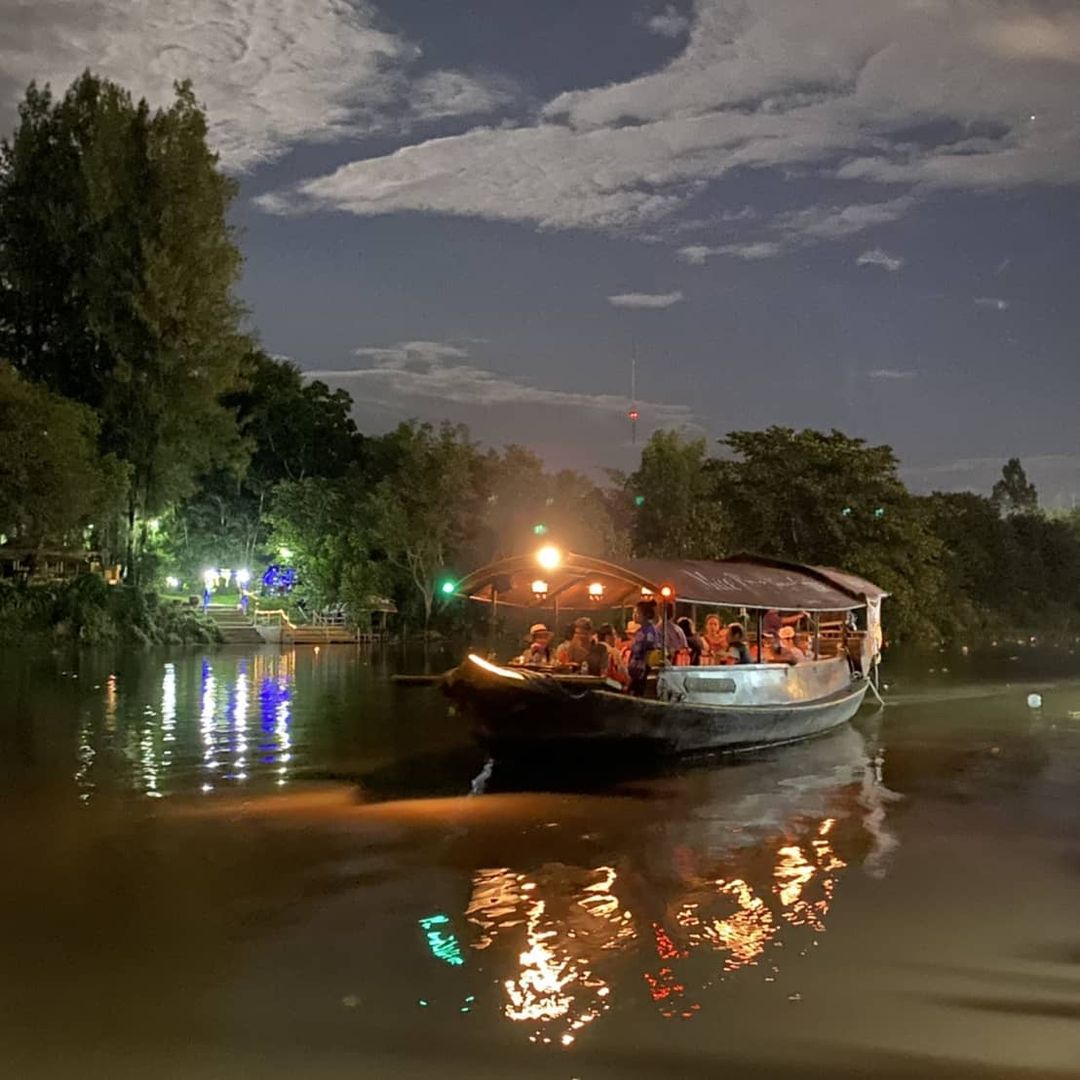 A Mae Ping River Cruise boat slowly making its way down river in the early evening.